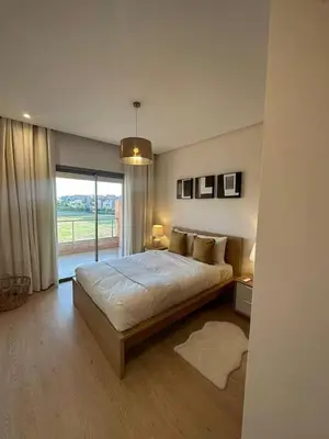 a bedroom with a large bed and a large window at apartment sur GOLF prestigia avec piscine in Marrakech