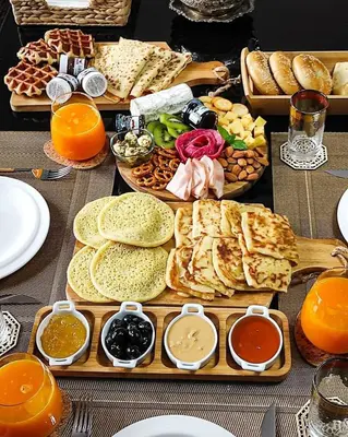 a table topped with different types of bread and dips at apartment sur GOLF prestigia avec piscine in Marrakech