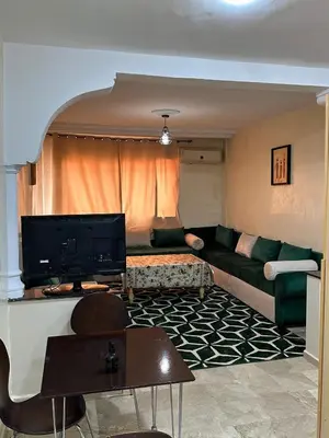 a living room with a couch and a tv at Le Chaleureux 34 face de la gare CTM Hivernage in Marrakech