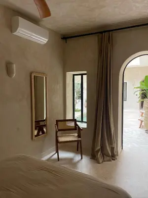 a bedroom with a bed and a chair and a window at Riad Roca in Marrakech