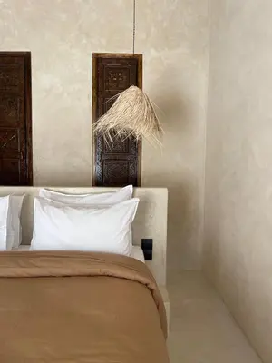 a bedroom with a bed with white pillows and a chandelier at Riad Roca in Marrakech