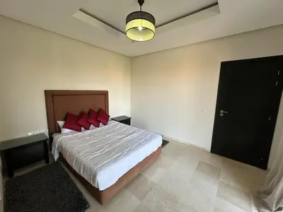 a bedroom with a large bed with red pillows at Duplex à l hivernage in Marrakech