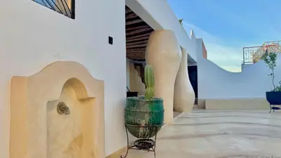 a cactus in a pot sitting on the side of a building at Riad Le Jardin des Matières in Marrakech