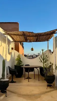 a patio with a table and some potted plants at Riad Le Jardin des Matières in Marrakech