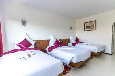 a room with two beds with red and white pillows at Hotel Le Grand Imilchil in Marrakech