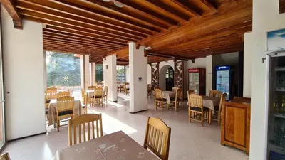 a dining room with wooden ceilings and tables and chairs at Hotel Le Grand Imilchil in Marrakech