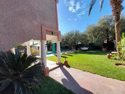 a house with a yard with a palm tree at Jasmin d'Atlas in Marrakech