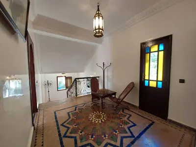 a living room with a table and a door at Jasmin d'Atlas in Marrakech