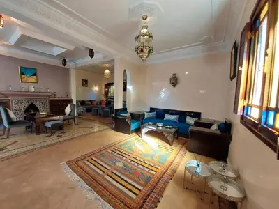 a living room with a blue couch and a fireplace at Jasmin d'Atlas in Marrakech