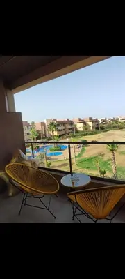 a balcony with two tables and a view of a pool at Prestigia réve in Marrakech