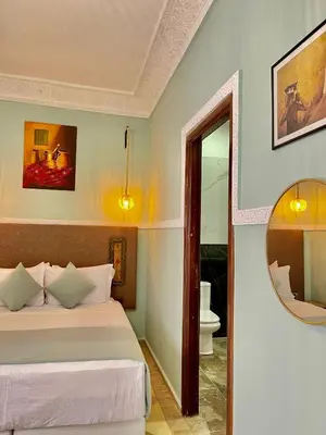 a bedroom with a bed and a mirror at Riad Al Wafaa in Marrakech