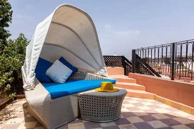 a wicker chair with a canopy on a patio at Riad Al Wafaa in Marrakech