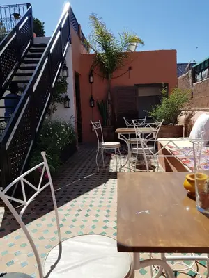 a patio with a table and chairs and stairs at Riad Al Wafaa in Marrakech