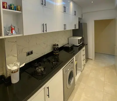 a kitchen with white cabinets and a washing machine at Appartement Idéal pour Votre Séjour in Marrakech