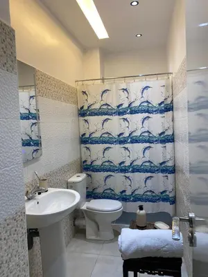 a bathroom with a sink toilet and a shower curtain at Appartement Idéal pour Votre Séjour in Marrakech
