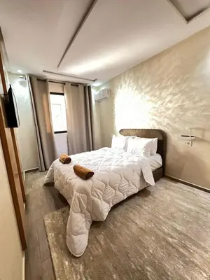a bedroom with a large bed with white sheets and pillows at Calm apartment 10 min from Majorelle Garden in Marrakech