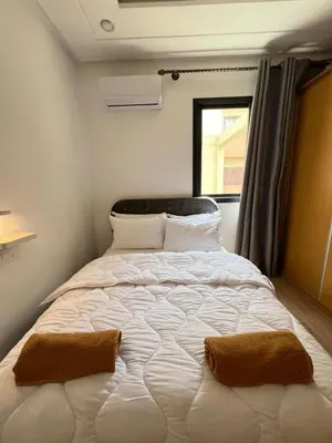 a large bed in a small room with a window at Calm apartment 10 min from Majorelle Garden in Marrakech