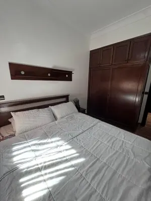 a bedroom with a large bed with a wooden headboard at RENTSUITE APPARTEMENT Premium Village Luxurious Residence in Marrakech