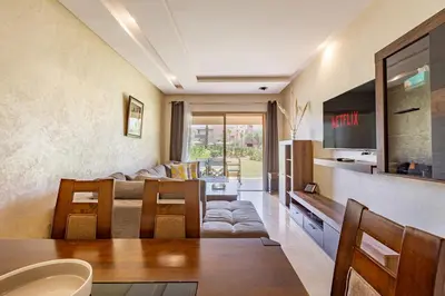 a living room with a couch and a table at Luxury Garden-Level Apartment with Poolside Serenity in Marrakech