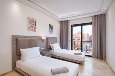 a hotel room with two beds and a window at Appart Hyper-Centre Gueliz - Wifi - Netflix in Marrakech