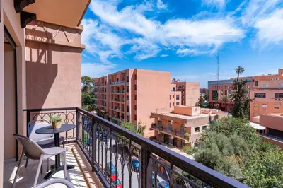 a balcony with a table and chairs and buildings at Appart Hyper-Centre Gueliz - Wifi - Netflix in Marrakech