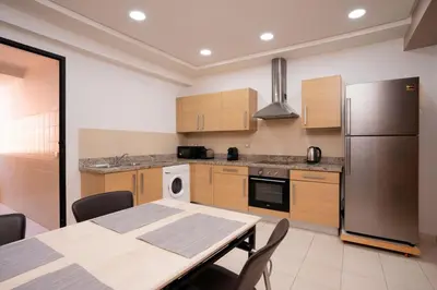 a kitchen with a table and a stainless steel refrigerator at Appart Hyper-Centre Gueliz - Wifi - Netflix in Marrakech