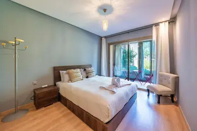 a bedroom with a large bed and a window at Apart Confort Rez-de-Jardin Piscine Wi-Fi Terrasse in Marrakech