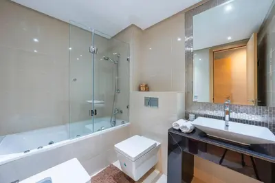 a bathroom with a sink and a shower and a toilet at Apart Confort Rez-de-Jardin Piscine Wi-Fi Terrasse in Marrakech