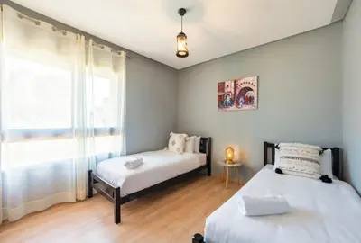 a bedroom with two beds and a window at Apart Confort Rez-de-Jardin Piscine Wi-Fi Terrasse in Marrakech