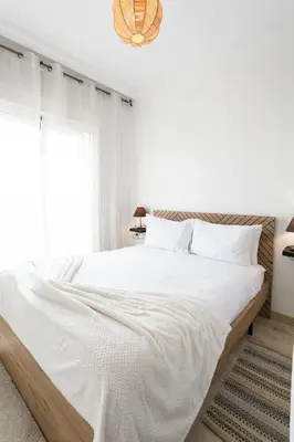 a bedroom with a large bed with white sheets at Le Joyau De Majorelle - Marrakech in Marrakech