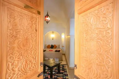a room with a door with a table and a bed at Riad Tampacao in Marrakech