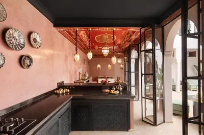 a kitchen with pink walls and a ceiling with chandeliers at Riad Dar Acsameda & Spa in Marrakech