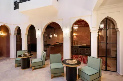 a lobby with chairs and tables and a kitchen at Riad Dar Acsameda & Spa in Marrakech
