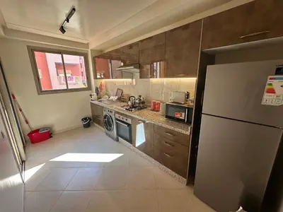a kitchen with a refrigerator and a stove top oven at Luxury Apartment in Central Marrakech - Pool & Fast Wi-Fi in Marrakech