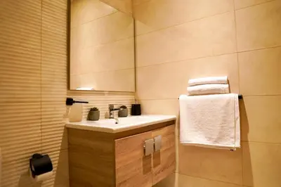 a bathroom with a sink and a mirror and towels at Appartement chambre et salon Perle20 Gueliz in Marrakech