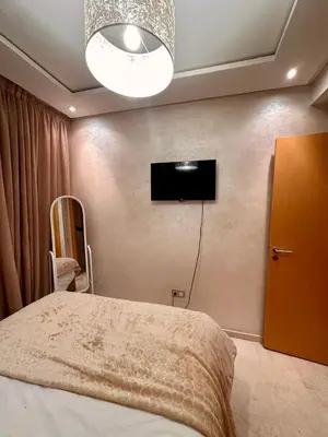a bedroom with a bed and a tv on the wall at Appartement chambre et salon Perle20 Gueliz in Marrakech