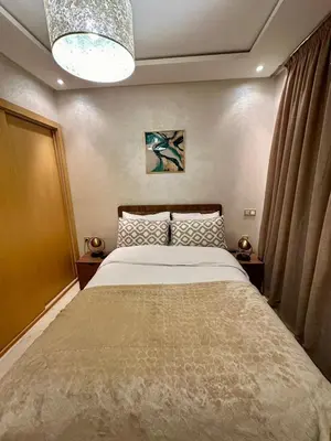 a bedroom with a large bed and a chandelier at Appartement chambre et salon Perle20 Gueliz in Marrakech