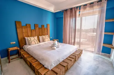 a bedroom with a large bed with blue walls at vue imprenable sur les jardins de la villa d Yves saint Laurent in Marrakech