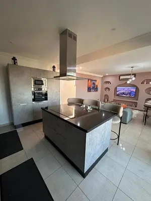 a kitchen with a large island in a living room at Apartment Gueliz Victor Hugo in Marrakech
