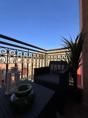 a balcony with a couch and a chair on a balcony at Apartment Gueliz Victor Hugo in Marrakech