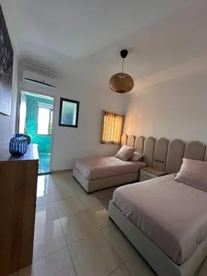 a bedroom with two beds and a couch at Apartment Gueliz Victor Hugo in Marrakech