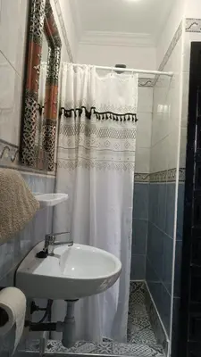 a bathroom with a white shower curtain and a sink at MARRAKECh TYPICAL HOUSE MAISON TYPIQUE MARRAKECH G2 40 in Marrakech