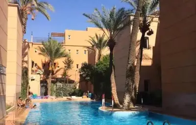 a swimming pool with palm trees in a resort at MARRAKECh TYPICAL HOUSE MAISON TYPIQUE MARRAKECH G2 40 in Marrakech