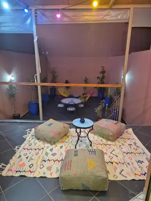 a room with two beds and a table and chairs at El Méhénni Guéliz JACUZZI 6 Personnes Terrasse Privative in Marrakech