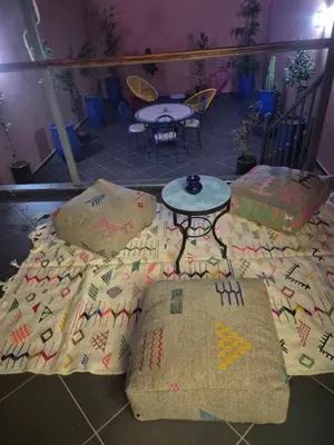 a bed with pillows and a table in a room at El Méhénni Guéliz JACUZZI 6 Personnes Terrasse Privative in Marrakech