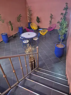 a patio with tables and chairs and plants at El Méhénni Guéliz JACUZZI 6 Personnes Terrasse Privative in Marrakech