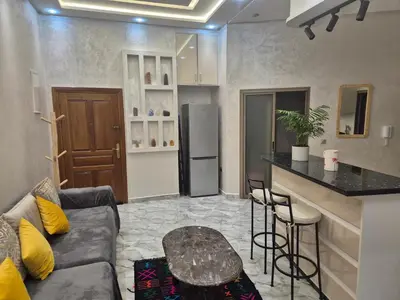 a living room with a couch and a kitchen with a counter at El Méhénni Guéliz JACUZZI 6 Personnes Terrasse Privative in Marrakech