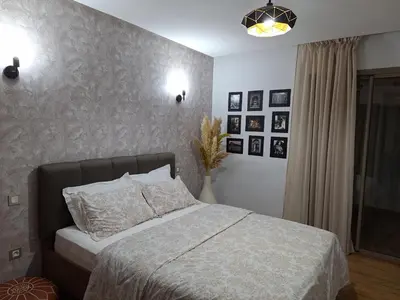 a bedroom with a bed and a wall with pictures at Bel appartement à Marrakech dans la résidence Pearl Garden avec piscine située sur la route de Casablanca Sa grande terrasse a une splendide vue sur la ville et les montagnes de l'Atlas A quelques minutes du centre ville et du grand Stade de Marrakech in Marrakech