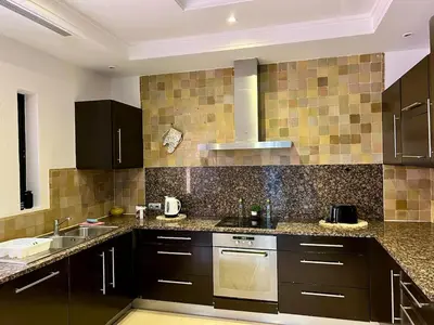 a kitchen with brown cabinets and a sink at Riad in Hotel M Avenue in Marrakech