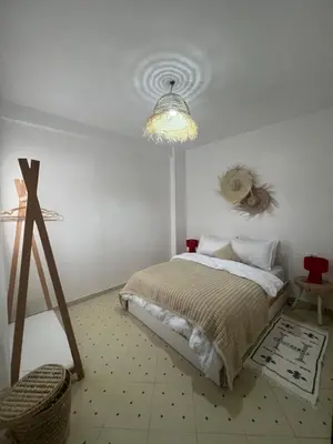 a bedroom with a bed and a chandelier at Aeroport appartement in Marrakech